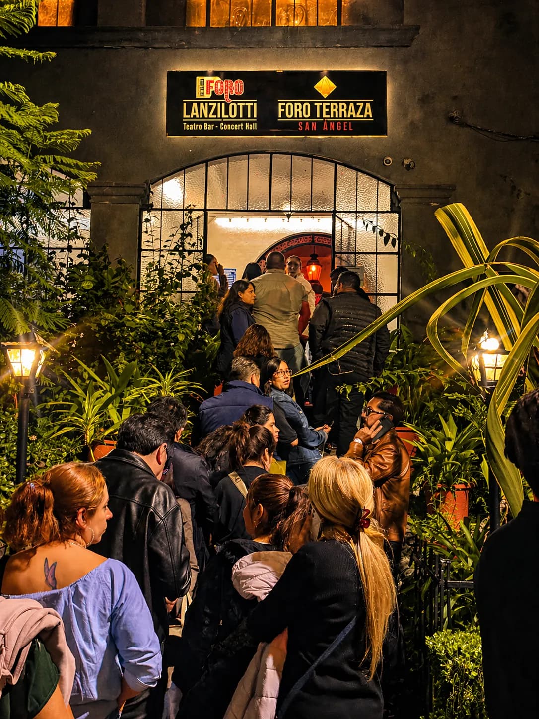 La entrada del recinto de noche, con el público llegando