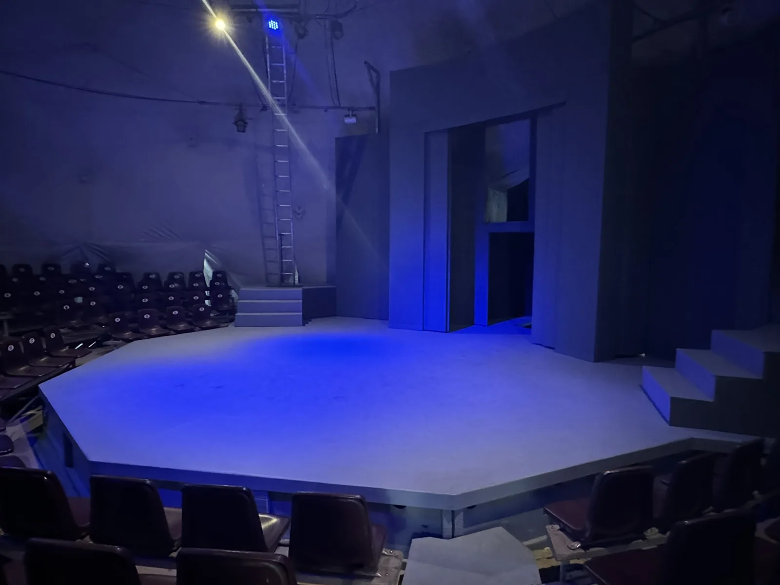 El escenario semicircular de la Carpa bajo luz azul, visto desde las butacas
